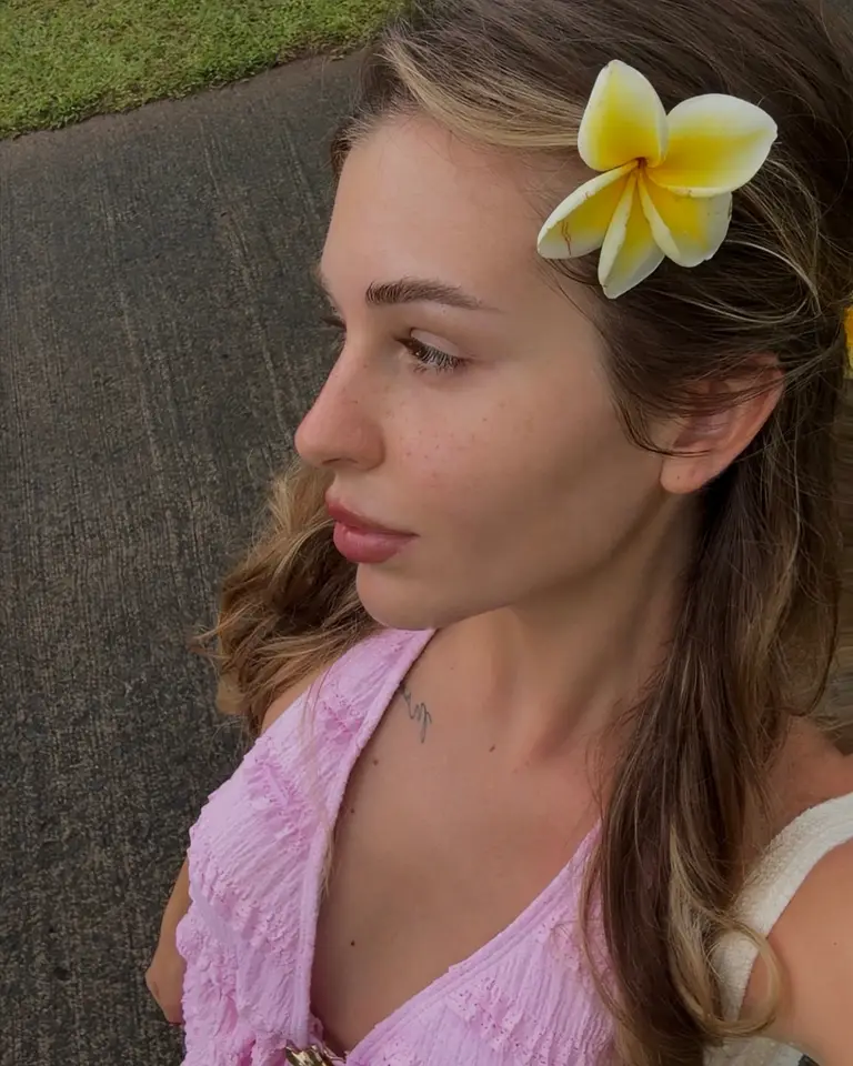 Nina with a plumeria flower in her hair, in soft daylight